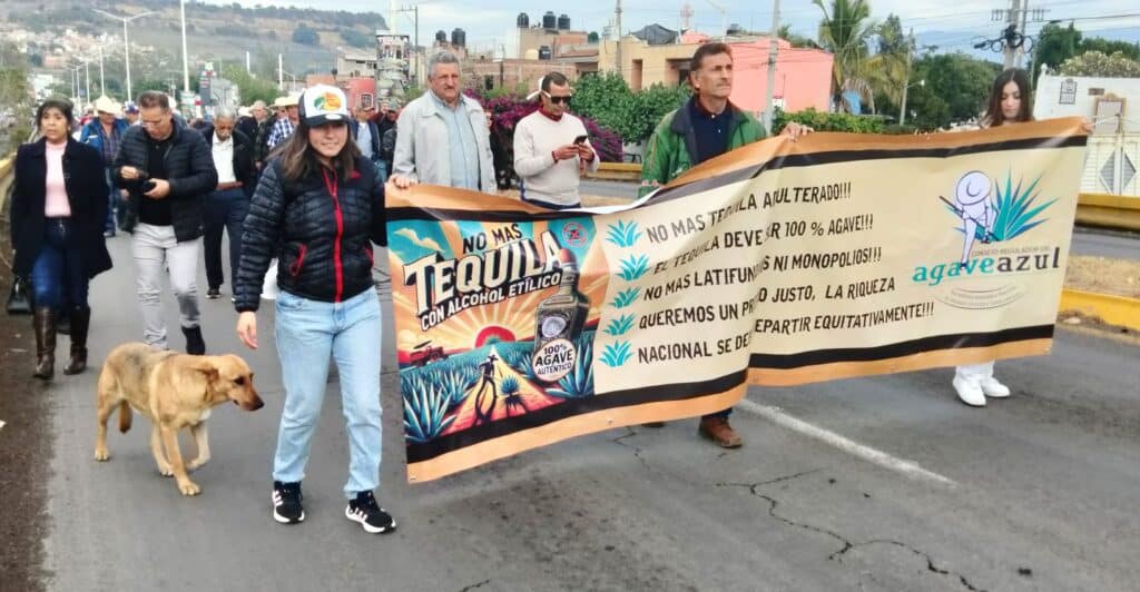 A protest in Tequila, Mexico. The image shows protestors holding a banner alleging tequila industry corruption.