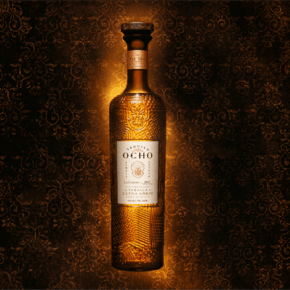 A bottle of Tequila Ocho extra anejo against a rich backdrop