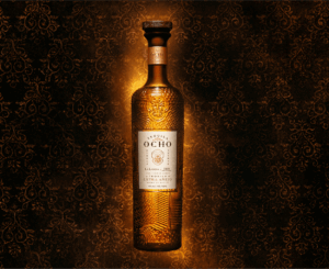 A bottle of Tequila Ocho extra anejo against a rich backdrop