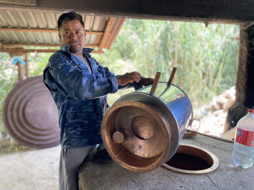 Omar demonstrates the internal workings of a still at a palenque in Oaxaca. We can see the refrescadora. 
